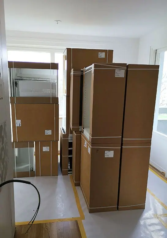 Korteri kolimine Tartus – suurte kolimikastide virn toas, põrand kaitstud teibitud kattematerjaliga.