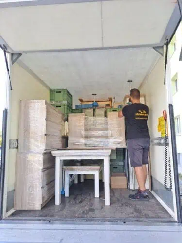 Kolimisteenus Tartus – kolija kinnitab veokastis kilesse pakitud mööbli tugipostiga.