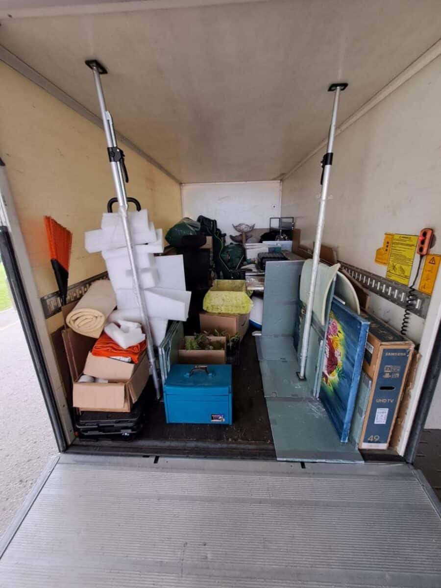 Kolimisauto Tartus – kastid, televiisori karp ja maalid kinnitatud tugipostidega veokasti sees.