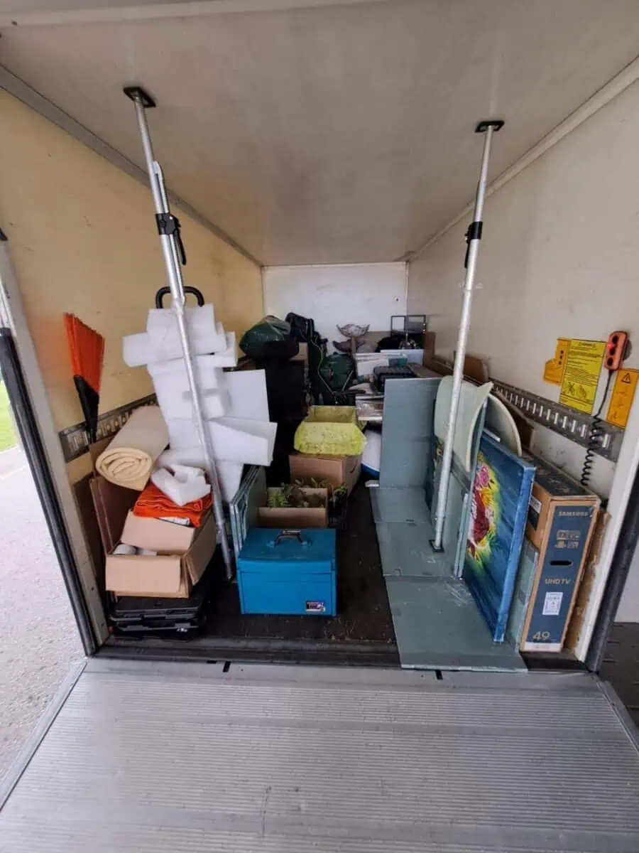 Kolimisauto Tartus – kastid, televiisori karp ja maalid kinnitatud tugipostidega veokasti sees.