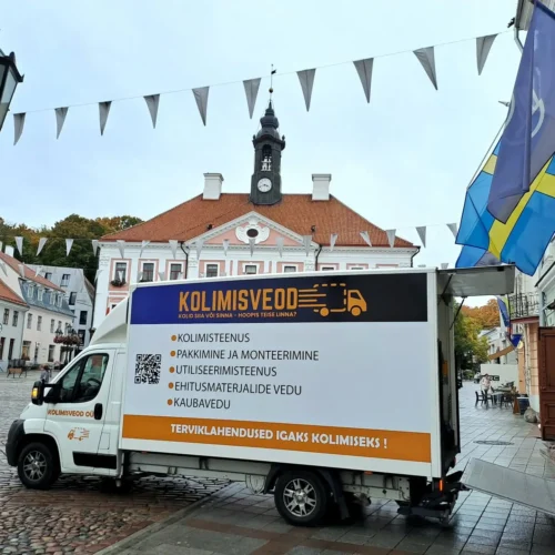 Kivisillutisel Tartu Raekoja platsil seisab Kolimisveod OÜ kaubik, mille küljel on loetletud teenused (kolimisteenus, pakkimine, utiliseerimine, kaubavedu). Tagaluuktõstuk on allalastud; taustal paistab raekoda ja lipumastid.