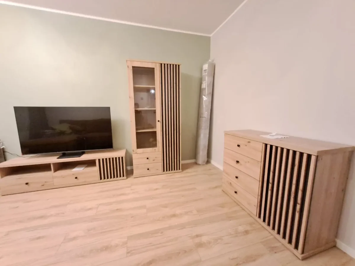 Korteri kolimine Tartus – paigaldatud puitmööbel ja televiisor elutoas, kolimisfirma lõpetatud töö.